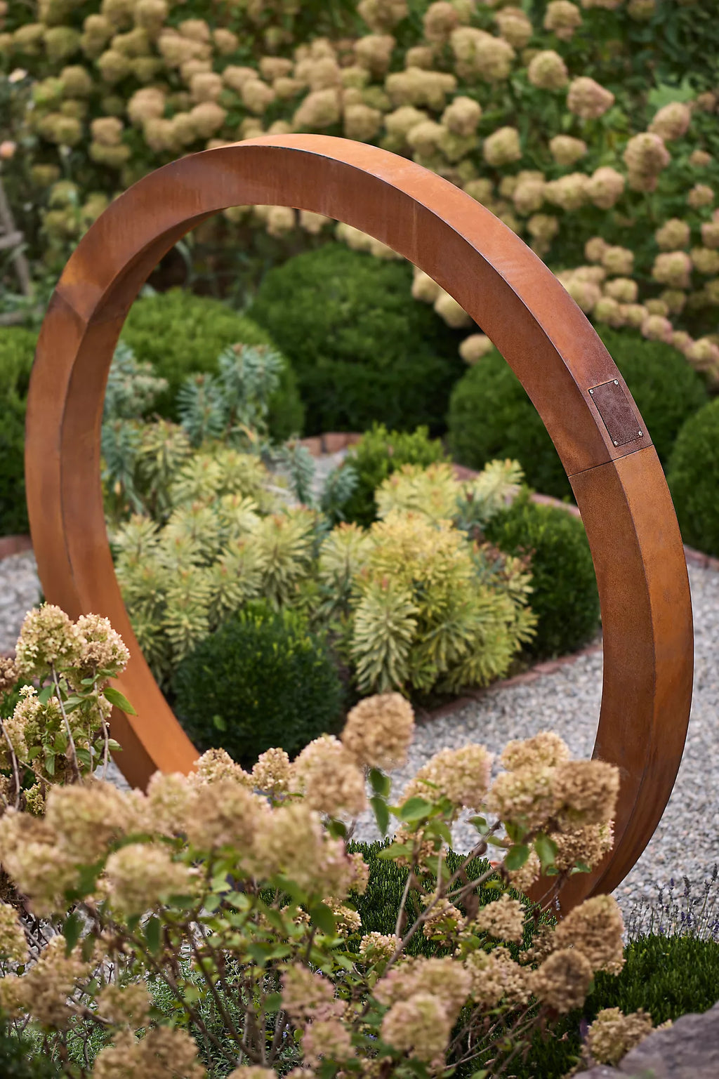 Close-up of corten steel Moongate garden sculpture, bold circular design