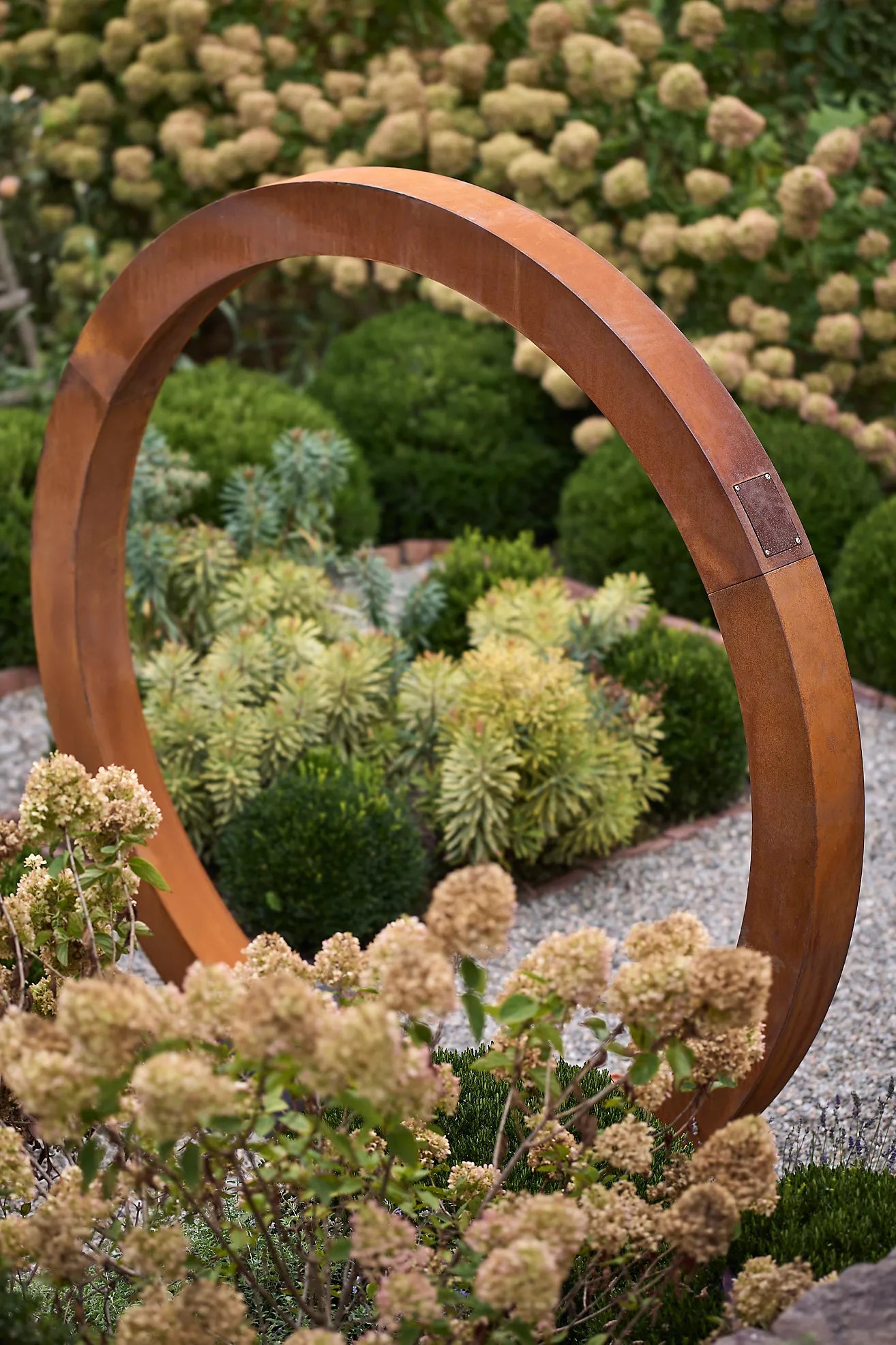Close-up of corten steel Moongate garden sculpture, bold circular design