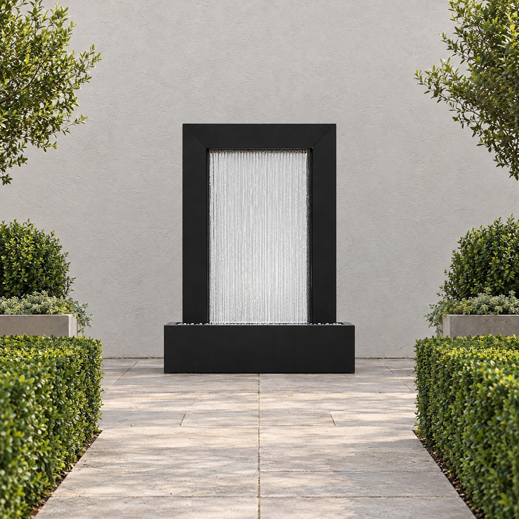 Serenity Frame black powder coated rain curtain fountain at the end of a paved garden path between clipped hedges