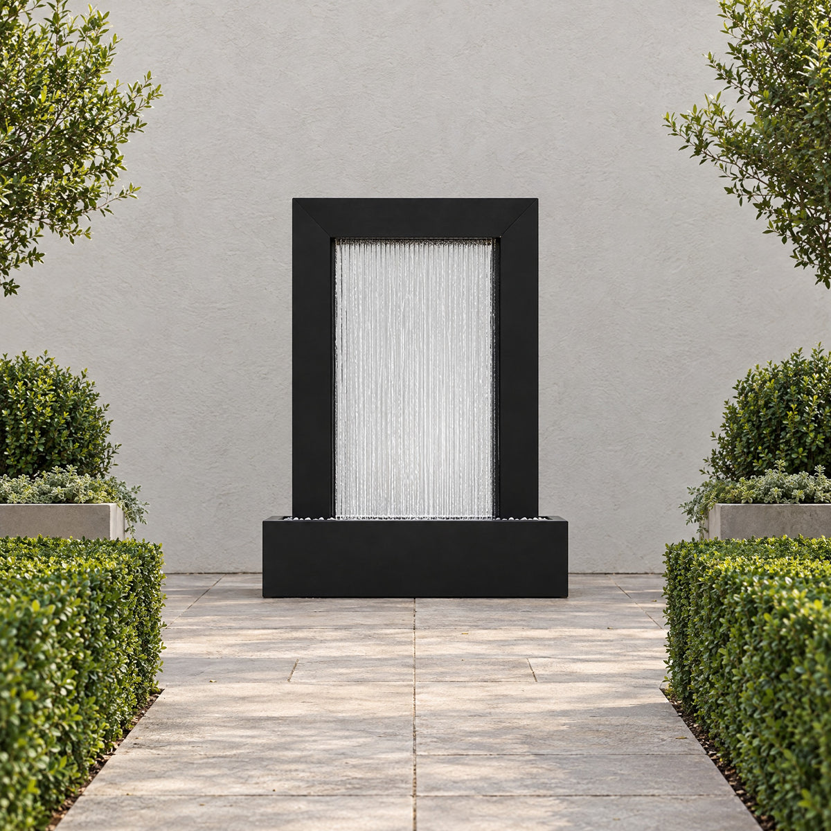 Serenity Frame black powder coated rain curtain fountain at the end of a paved garden path between clipped hedges